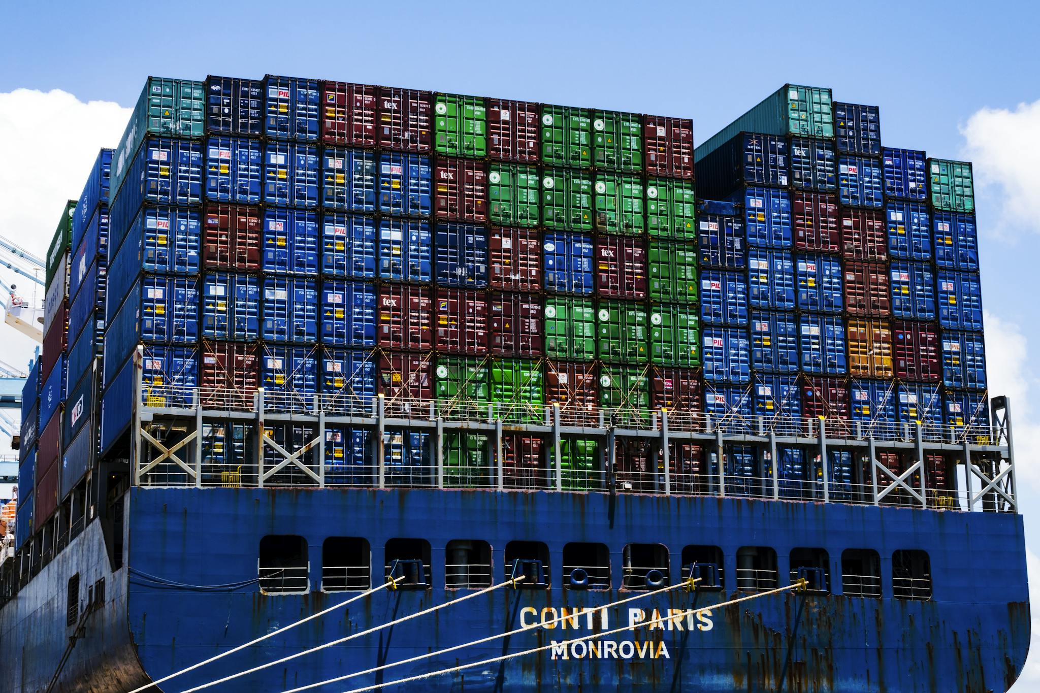 Stacked cargo containers on a massive ship at the harbor, symbolizing global trade.